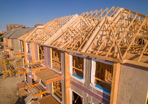 Clarified Standards Support Safety in Truss Design photo of a housing construction project with exposed roofing trusses
