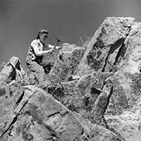 Dr. Diana Loranger, P.Geol. uses her pick hammer to gather rock samples in the Rocky Mountains (1947)