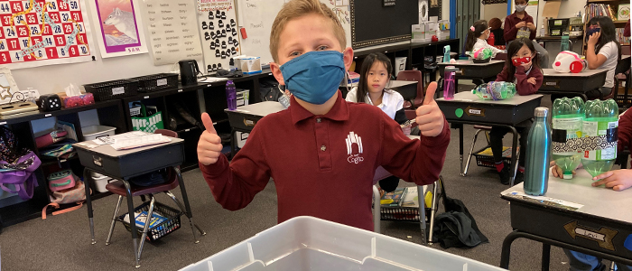 A student poses with two thumbs up as he tests his APEGA Science Olympics project