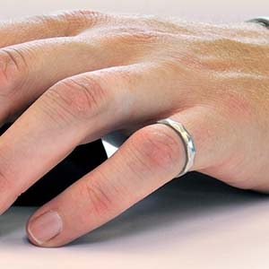 Close-up of a hand wearing an Iron Ring on the smallest finger