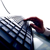 Closeup of a hand typing on a computer keyboard