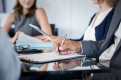 board-meeting-man holding pen on table