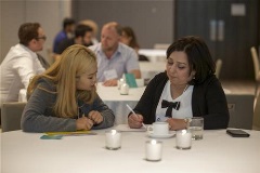 Mock Interviews - Sit with a manager or HR professional to practice your answers to common interview questions A young adult sits with an older adult to review a document together