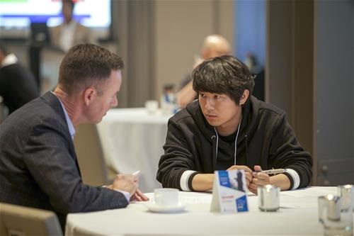 A young adult listening intently to an older professional