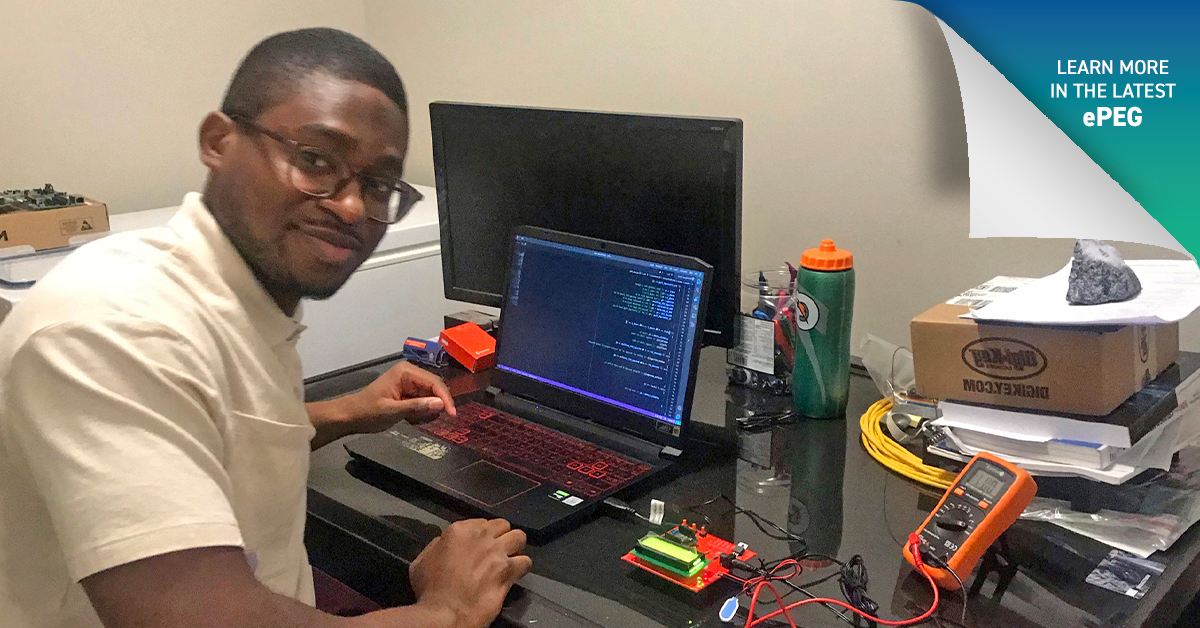 Habib Adesola Jinadu, E.I.T. at his laptop with electrical components spread across the desk